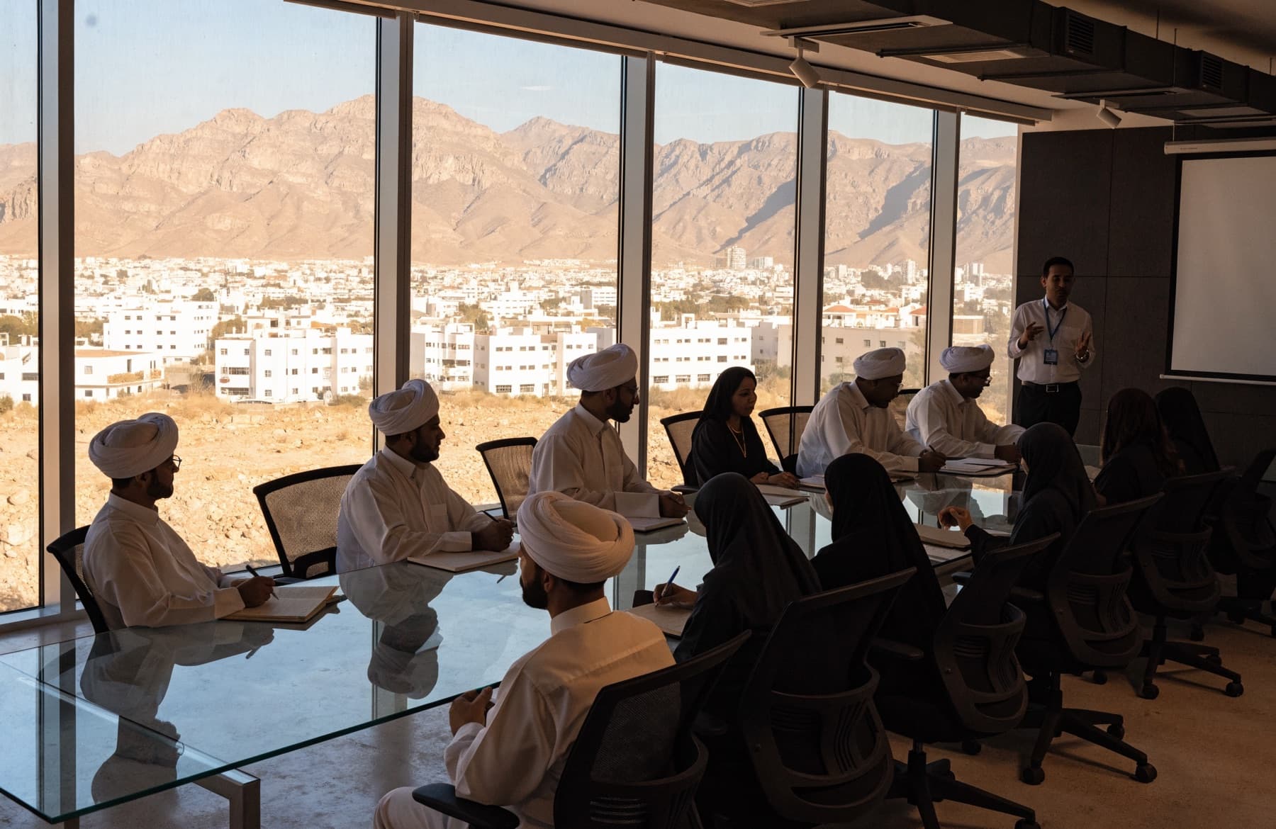 A corporate English session in a Muscat boardroom looking out at the mountains